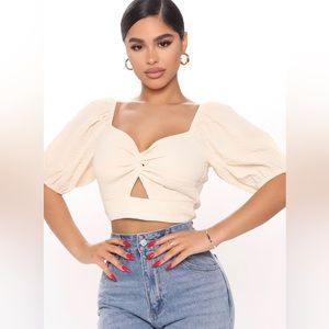 Beige crop top with puffy sleeves and twist on front size small.